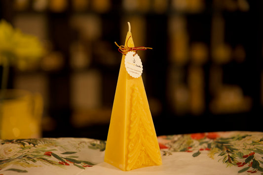 Elegant pyramid-shaped holiday candle in pure beeswax with evergreen motif, 2.5x7.25 inches