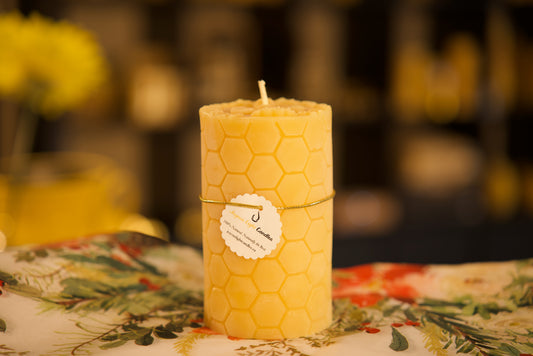 Artisanal pure beeswax pillar with honeycomb texture and decorative bee, natural honey-scented home accent